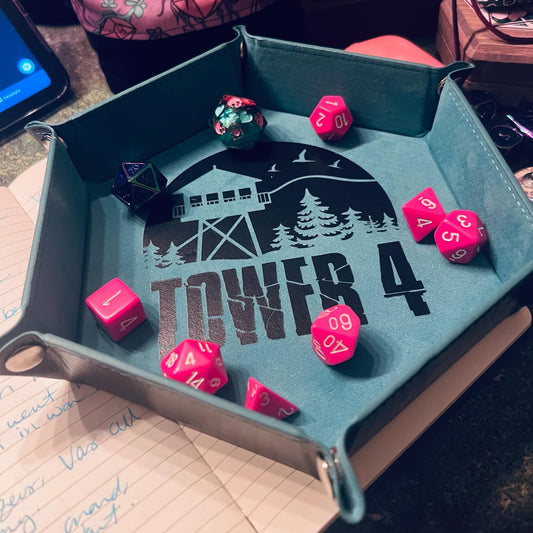 Dice tray with 'Tower 4' design holding pink dice on a table.